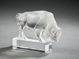 a glass figurine of a buffalo on a clear base