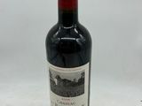 une bouteille de vin rouge posée sur une table blanche