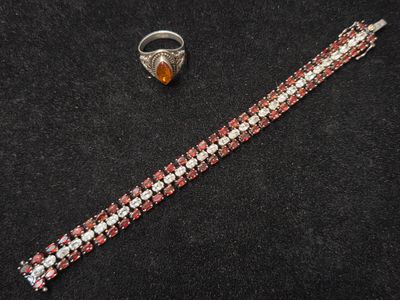 un gros plan d'un bracelet et d'une bague posés sur une surface noire
