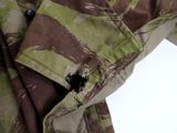 a close up of a camouflage shirt with a hole in it