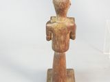statue of a man holding a bird on a wooden base