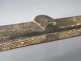 an old wooden box with a handle on a gray surface