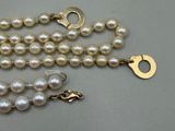 pearl necklace with a gold clasp on a white background