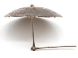 a silver umbrella that is sitting on a white surface