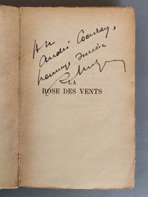 un livre ouvert, sur lequel figure un titre écrit à la main, posé sur une table