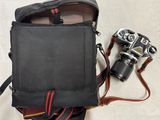 un sac noir contenant un appareil photo et une courroie