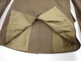 beige jacket with a bow on the back of it