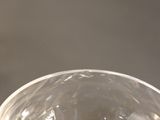 two wine glasses sitting on a table with a wine glass in the background