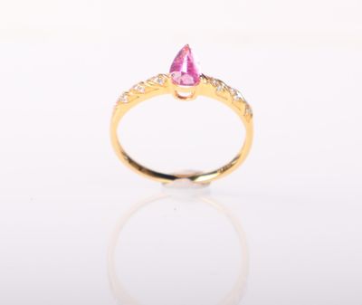 un gros plan sur une bague sertie d'un saphir rose et de diamants