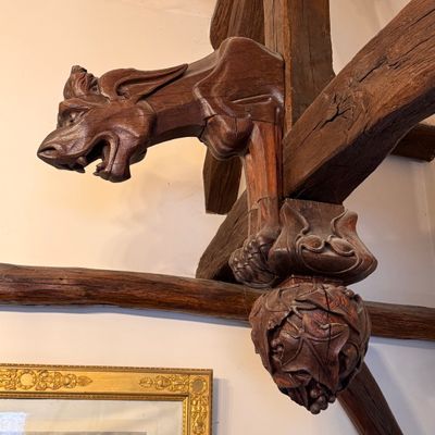 a wooden sculpture of a dragon hanging on a wall