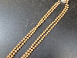 a close up of a wooden beaded necklace on a black surface