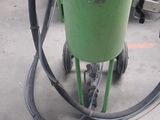 a green machine with a hose attached to it