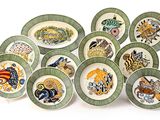 de nombreuses assiettes aux motifs variés, disposées sur un fond blanc