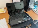a laptop computer sitting on top of a briefcase on a desk