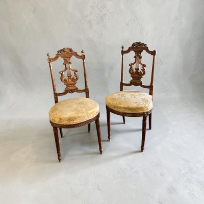 pair of antique chairs with upholstered seats in the shape of a lion and a bird