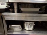 a metal shelf with pots and pans on it