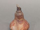un petit vase surmonté d'un oiseau