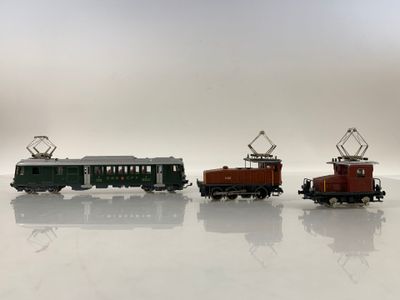 trois petits trains posés sur une surface blanche