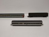 three model train cars sitting on top of a white table