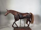 cheval en bois posé sur un socle, sur fond blanc