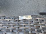 a close up of a woven chair with a metal tag on it