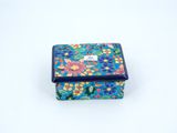 an image of a small blue and pink box with flowers on it