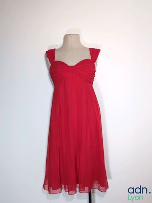 une robe rouge posée sur un présentoir à mannequin, sur fond blanc