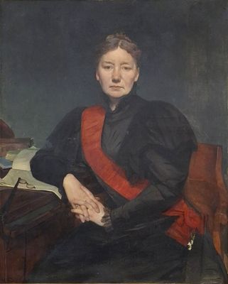 portrait d'une femme portant une écharpe rouge, assise à un bureau