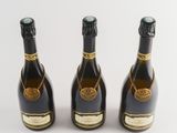 three bottles of champagne sitting next to each other on a white surface