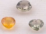 three different colored gems sitting on top of a white surface