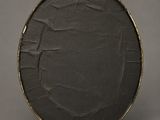 an old black drum case with gold trim on a gray background