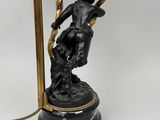 an image of a black and gold table lamp with a statue on it