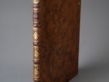 un vieux livre à la couverture brune posé sur une table