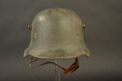 helmet on a stand on a gray background with a brown strap