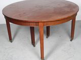 une table à manger ronde à quatre pieds, avec un plateau en bois