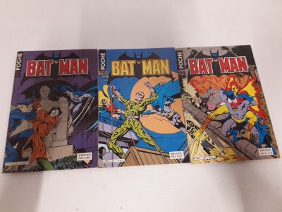 Trois bandes dessinées de Batman sont posées sur une surface blanche