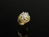 a gold and diamond ring on a black surface