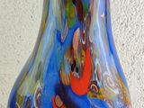 a colorful glass vase sitting on a white surface
