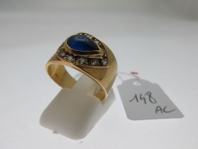 une image d'une bague en or avec une pierre bleue et des diamants