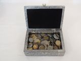 a silver box filled with coins sitting on a table