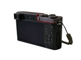 a black digital camera with a red light on it