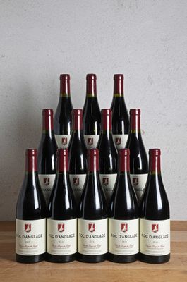 a bunch of bottles of wine sitting on top of a wooden table
