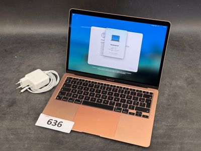 a laptop that is sitting on a table with a charger attached to it