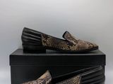 a pair of brown snakeskin slippers sitting on top of a black box