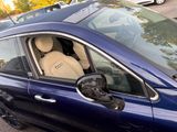 a dog sitting in the passenger seat of a car