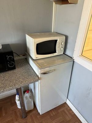 a microwave on top of a refrigerator in a kitchen