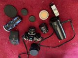 a lot of different cameras and lenses on the floor