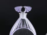three clear glass perfume bottles sitting on top of a black surface