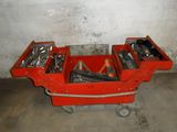 un chariot à outils rouge contenant des outils, dans un garage