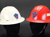 two hard hats are sitting next to each other on a black surface